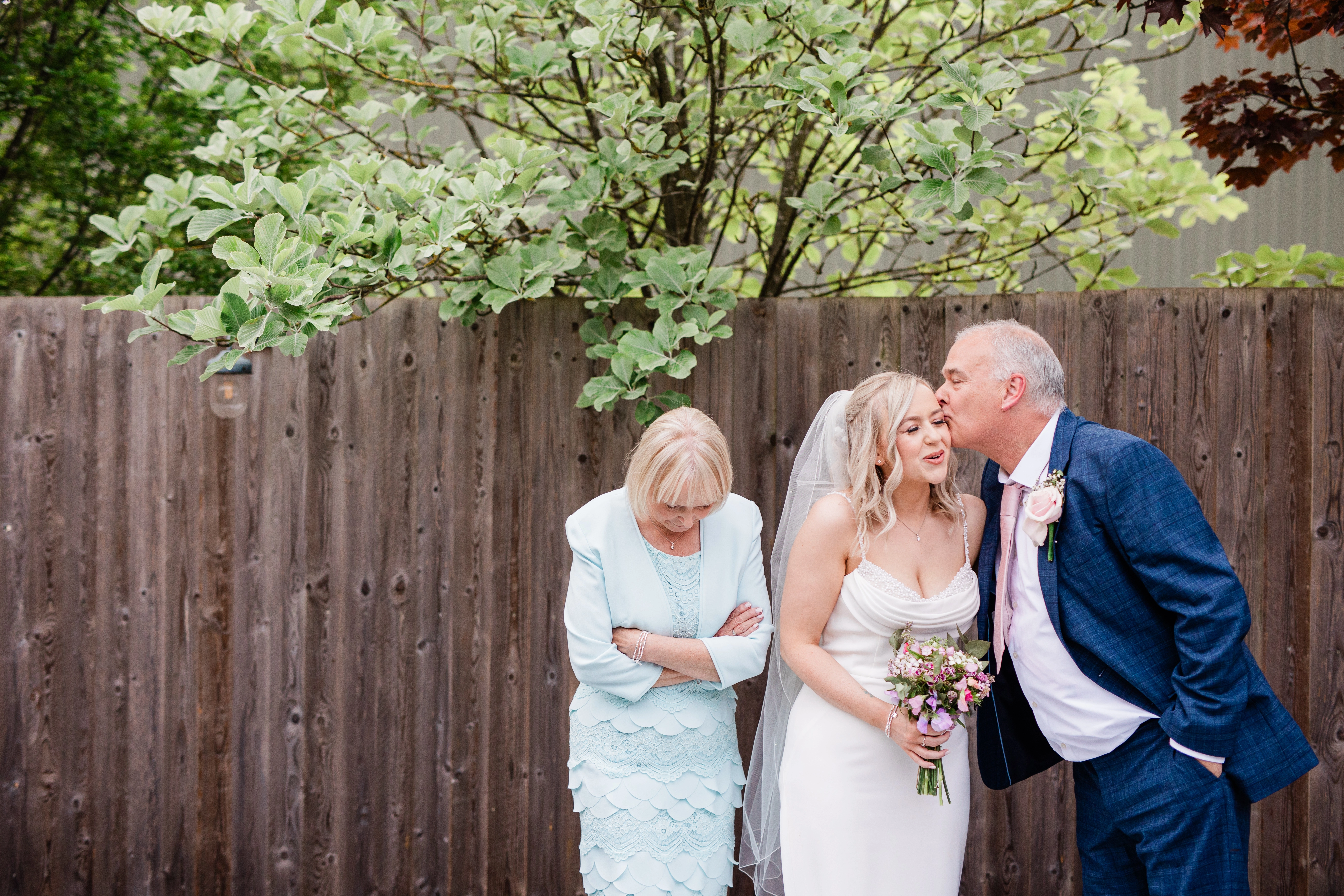 The father of the groom giving the bride a peck on the cheek