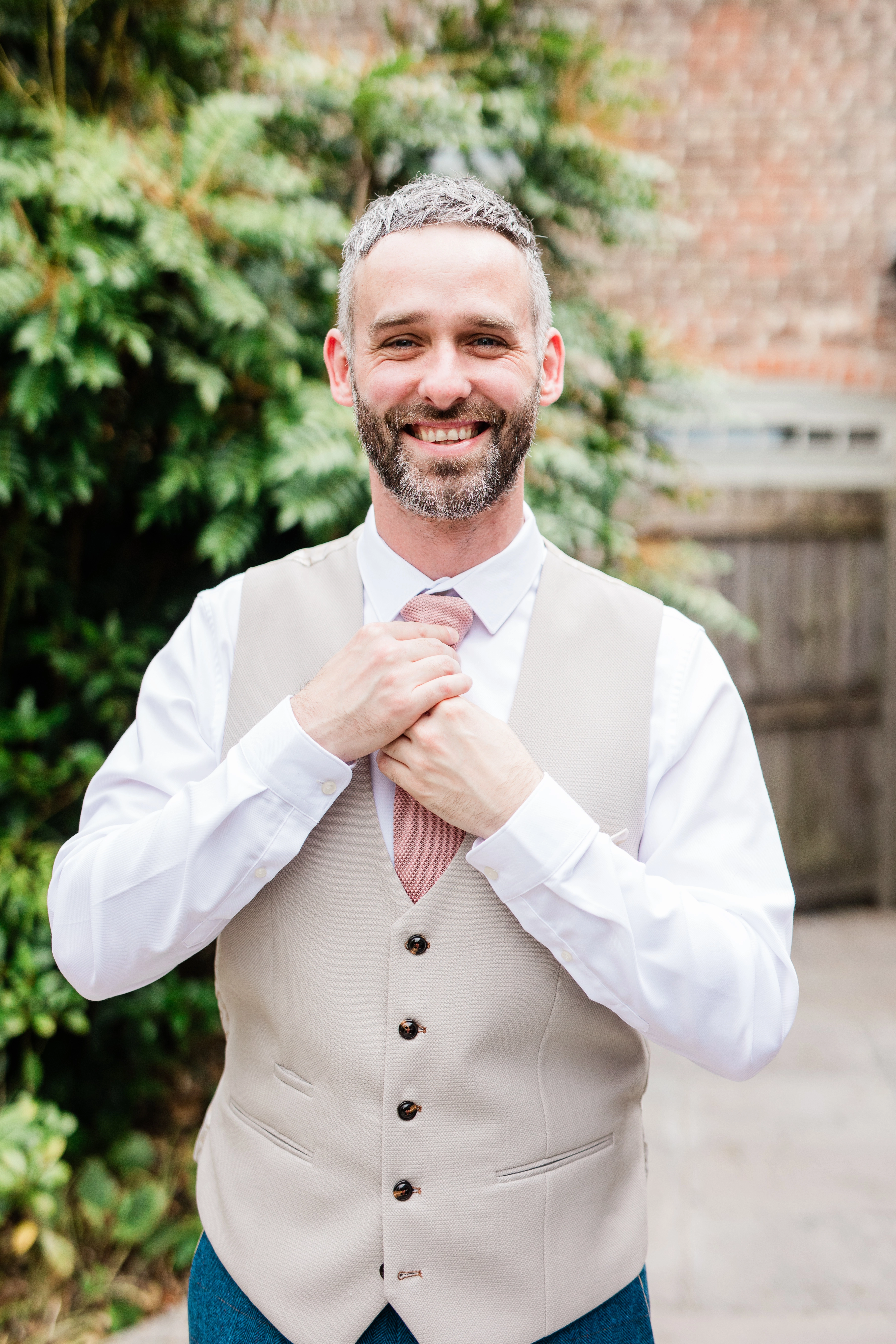 The groom straightening his tie