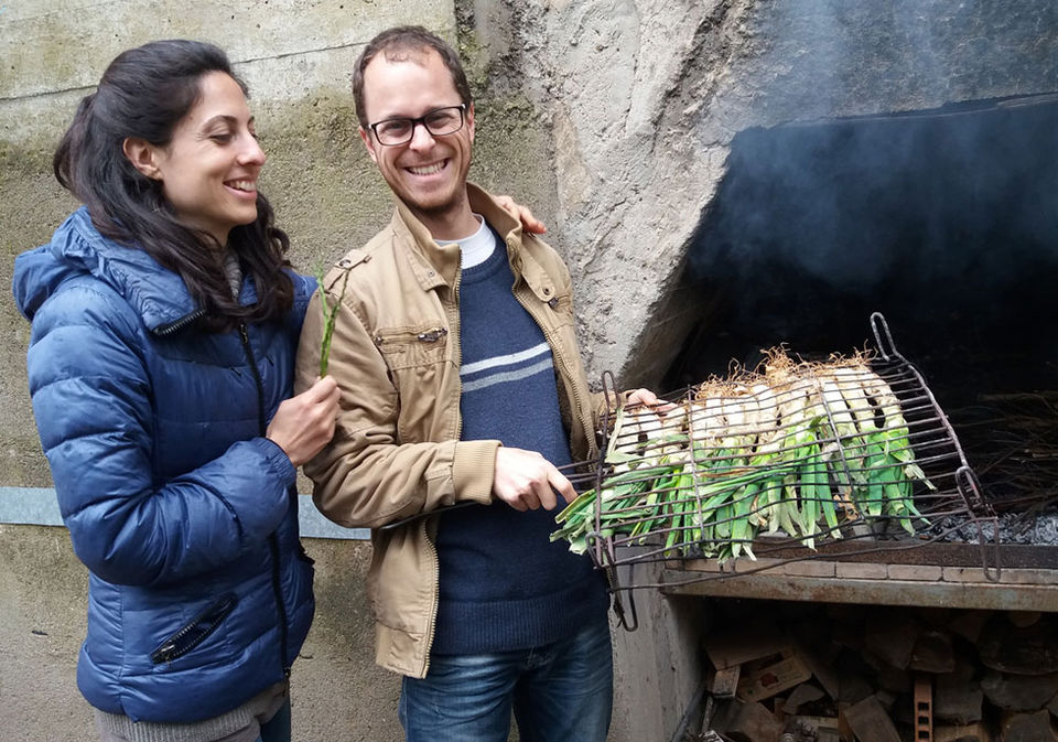 Cristina & Guillermo putting the calçots on the barbecue for a calçotada in Barcelona