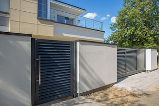 Moderne Gartentür aus Metall mit Lamellen vor einem Wohnhaus