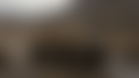 A Reuters-style editorial photo of a desert yellow TerraMate 6x6 logistics UGV carrying modular cargo boxes across rough gravel and muddy terrain, no visible weapons, no people facing camera, documentary defense industry photography