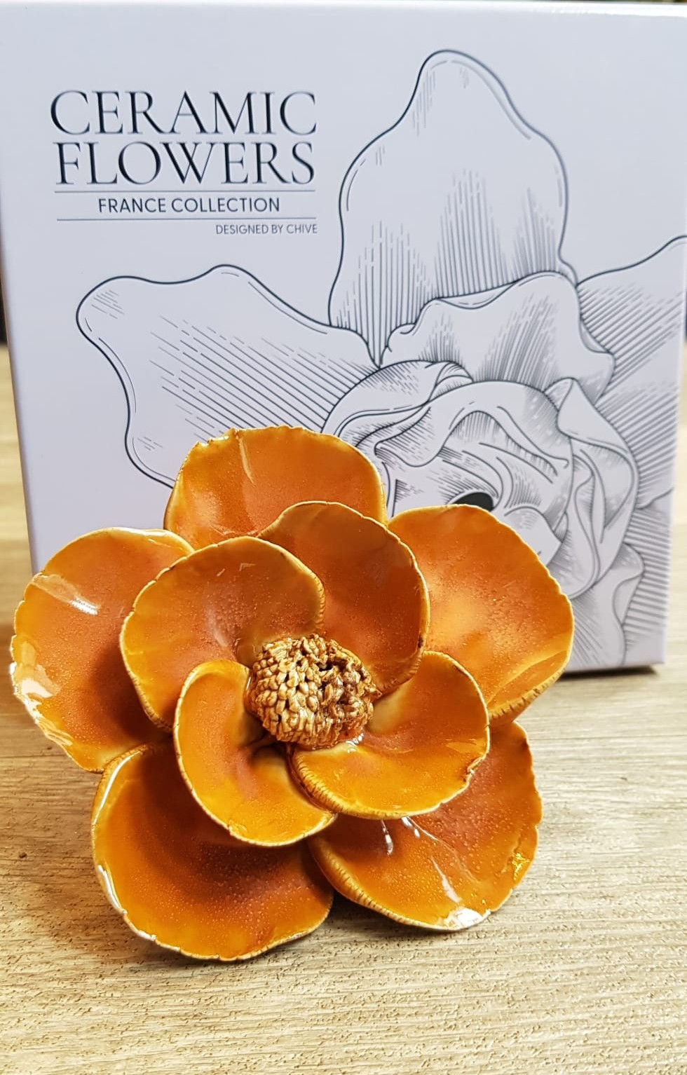 Ceramic Poppy Burnt Orange colour with a lilac gift box behind