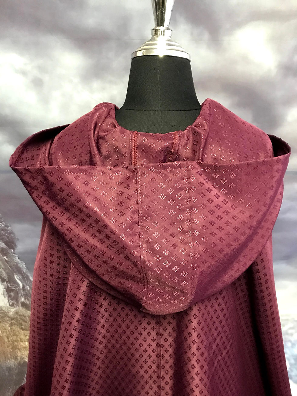 Thumbnail: Burgundy brocade cloak with oversize hood.