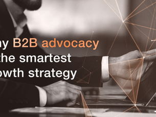 A black and white image of a businessman using a laptop at a desk.