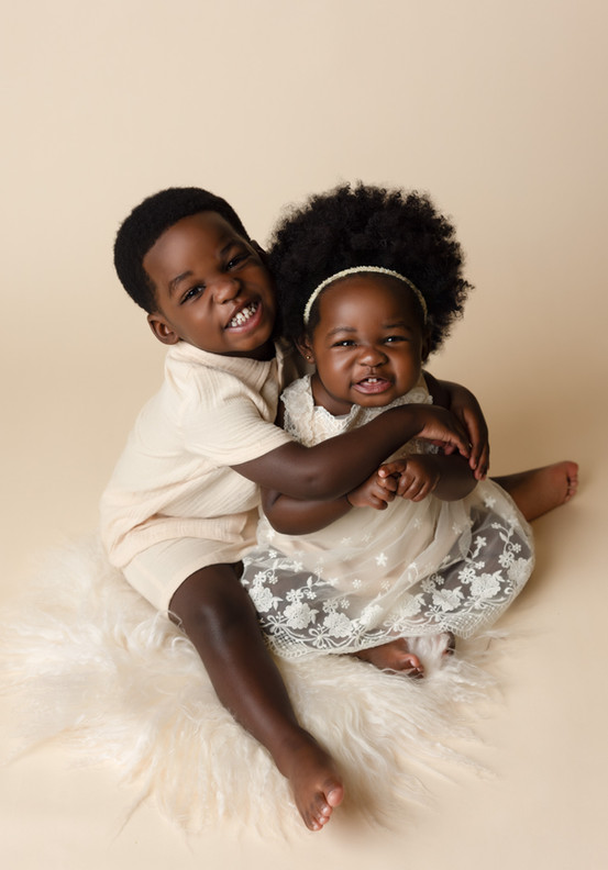 Smiling toddler siblings posing for a photo 