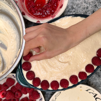 placing raspberries on top of the tiramisu