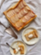 French apple tart with slices on plates, dollops of creme fraiche and a spoonful.