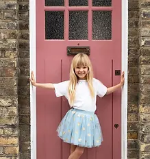 Young girl standing in a doorway wearing a tutu