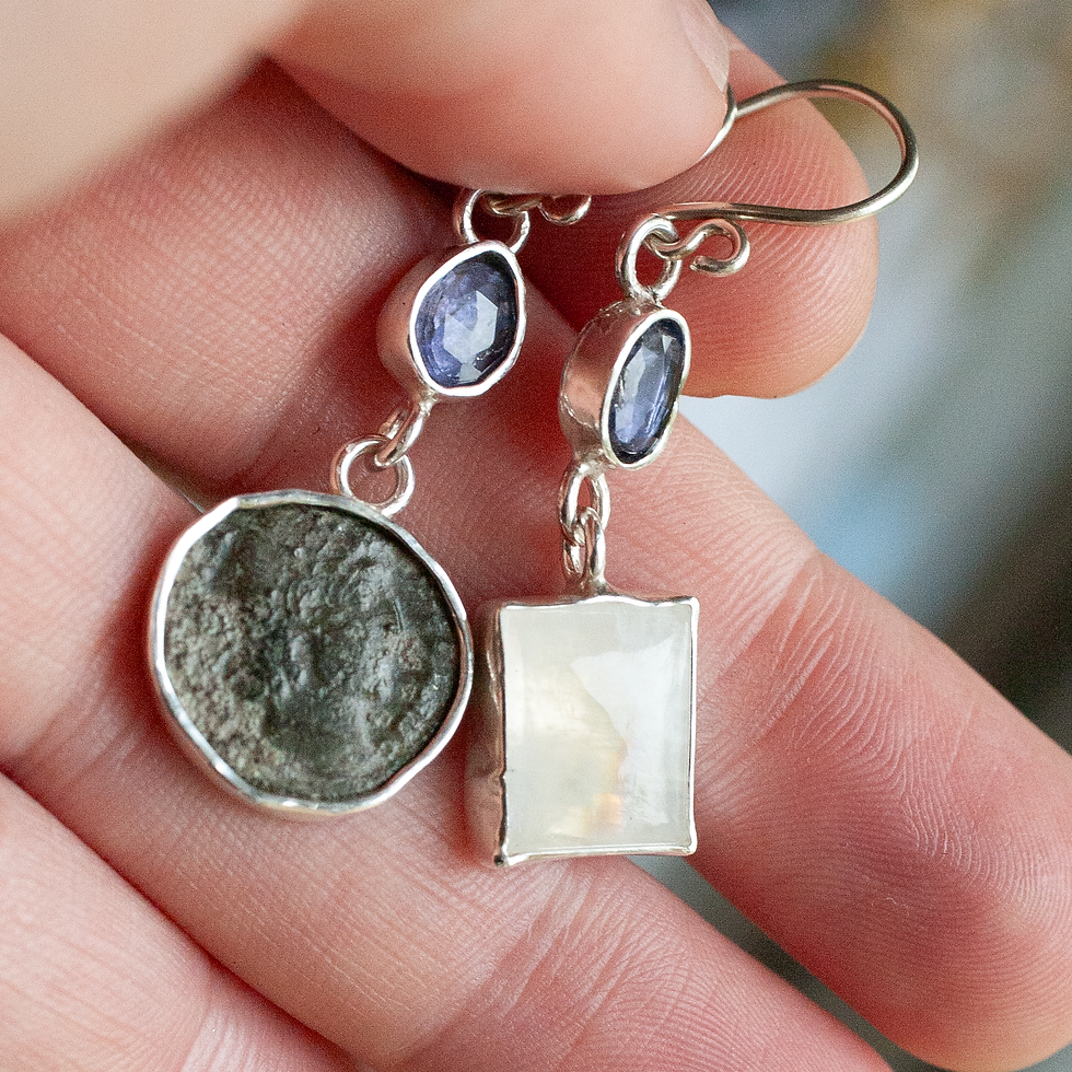 Thumbnail: Asymmetric Rome Earrings featuring Moonstone and Tanzanite. The face on the ancient coin is peeking out at us from the past.