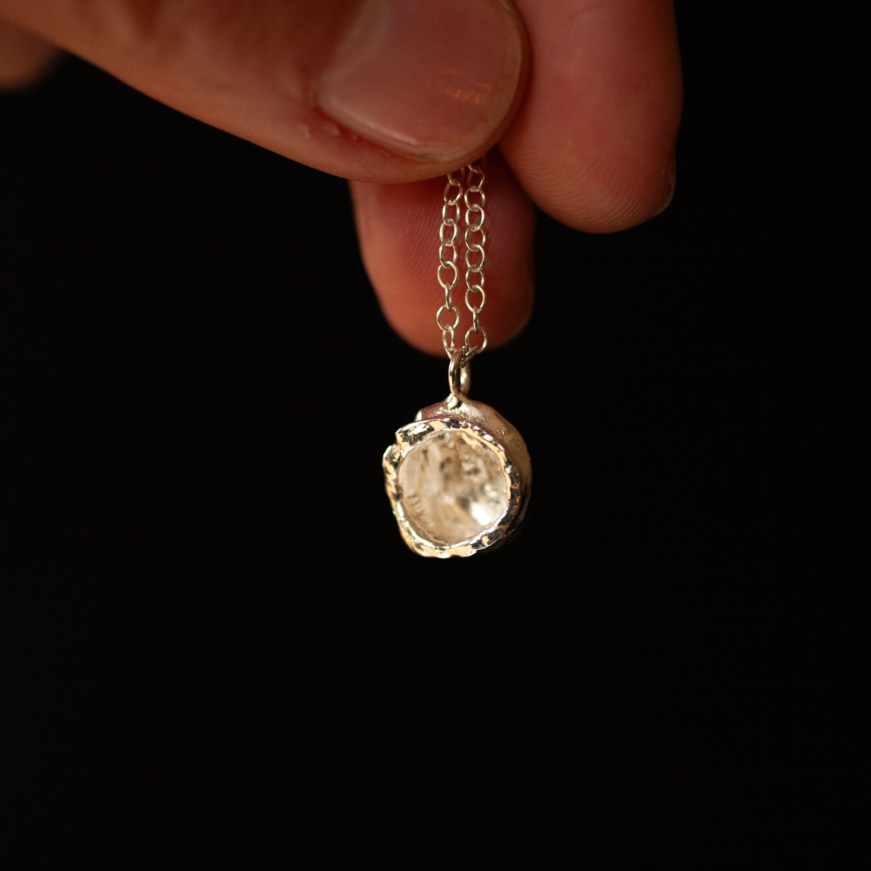 Chain with Splash charm pendant in silver held in hand