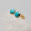 Thumbnail: Smooth round genuine turquoise stud earrings in golden setting