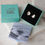 Thumbnail: pair of asymmetrical silver stud earrings in gift box with flyer