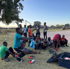 Young players in Zambia unpack a suitcase of donated cleats and jerseys (2022).