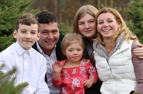 a happy family christmas photo including a girl with down syndrome