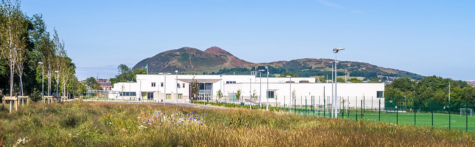 exterior architectural photography: white rendered school mountain backdrop