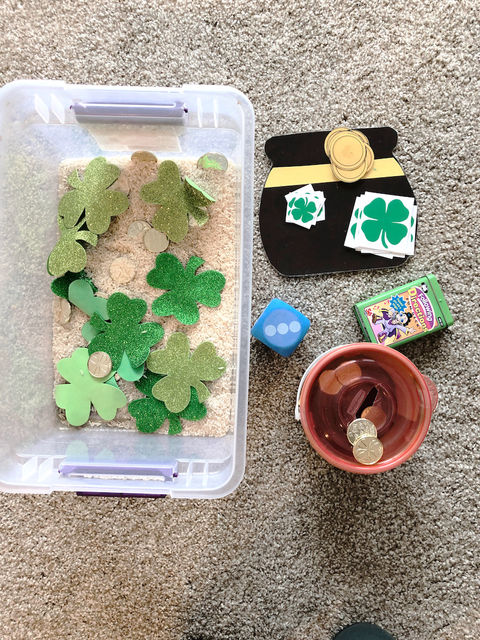 water bead sensory bin with ocean animals in a speech therapy session with shamrocks, gold coins, dice, and therapy cards