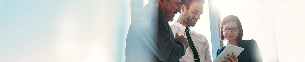 Dois homens e uma mulher em um escritório corporativo olhando para um dispositivo.