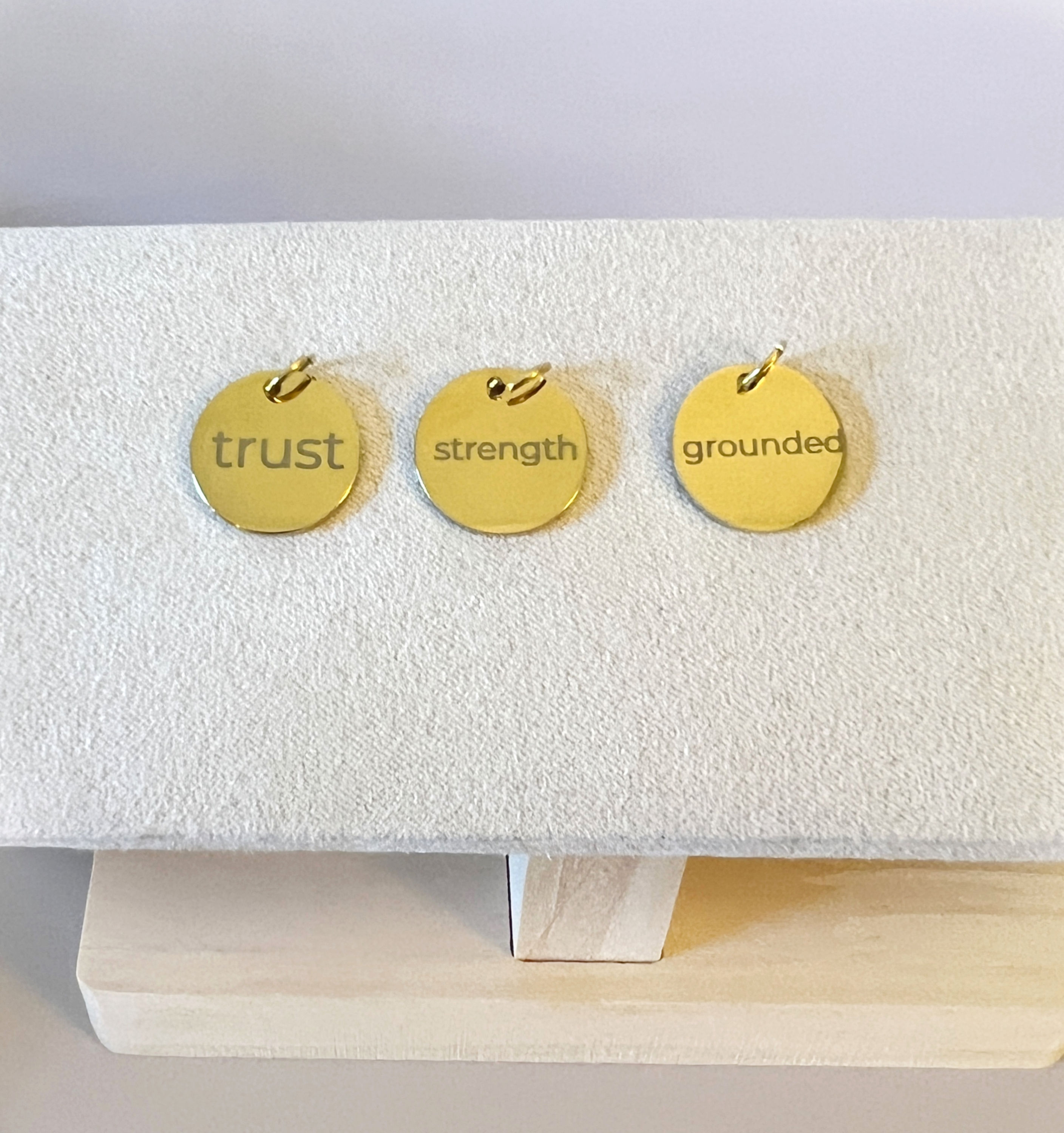 gold charms with words over head view