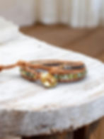 african turquoise leather wrap bracelet with gunmetal beads and gold oval button, on counter, over head