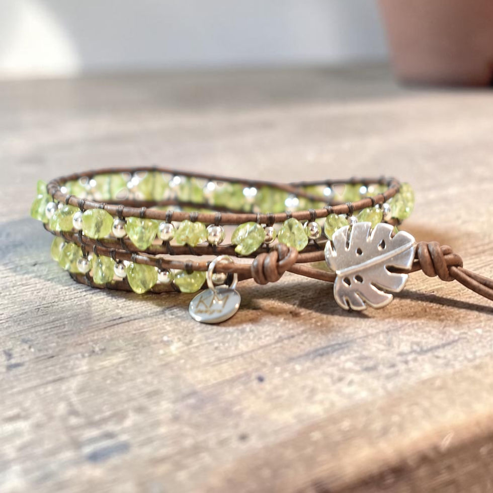 peridot and silver beaded leather wrap bracelet on wood counter