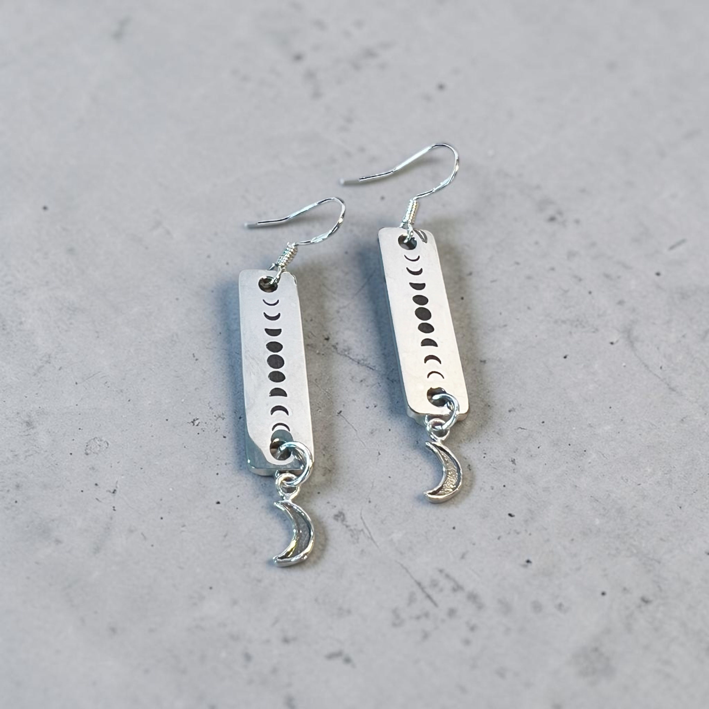 phases of the moon drop earrings overhead view