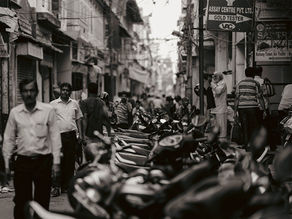 Busy street scene in India showing people, local businesses and everyday commercial activity.