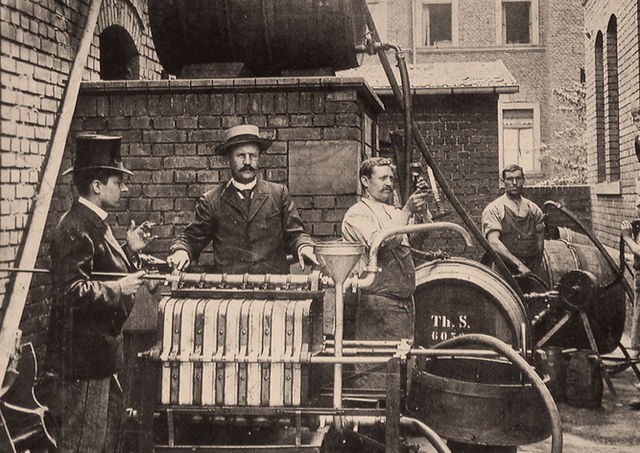 1896 präsentiert Theobald Seitz im Hof seiner Werkstatt eine für die Alluvialfiltration umgebaute Weinfilterpresse.