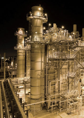 Eine große Industrieanlage wird in der Dunkelheit durch Beleuchtung in gelbes Lciht getaucht