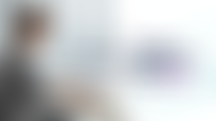 Eye-level view of a professional working on a laptop with instructional design software