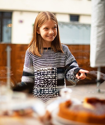 Lachendes Kind das auf Kuchen zeigt