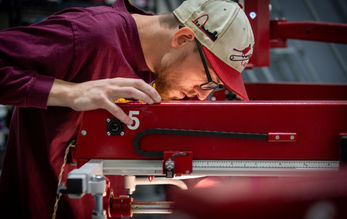 Waist up employee operating a press