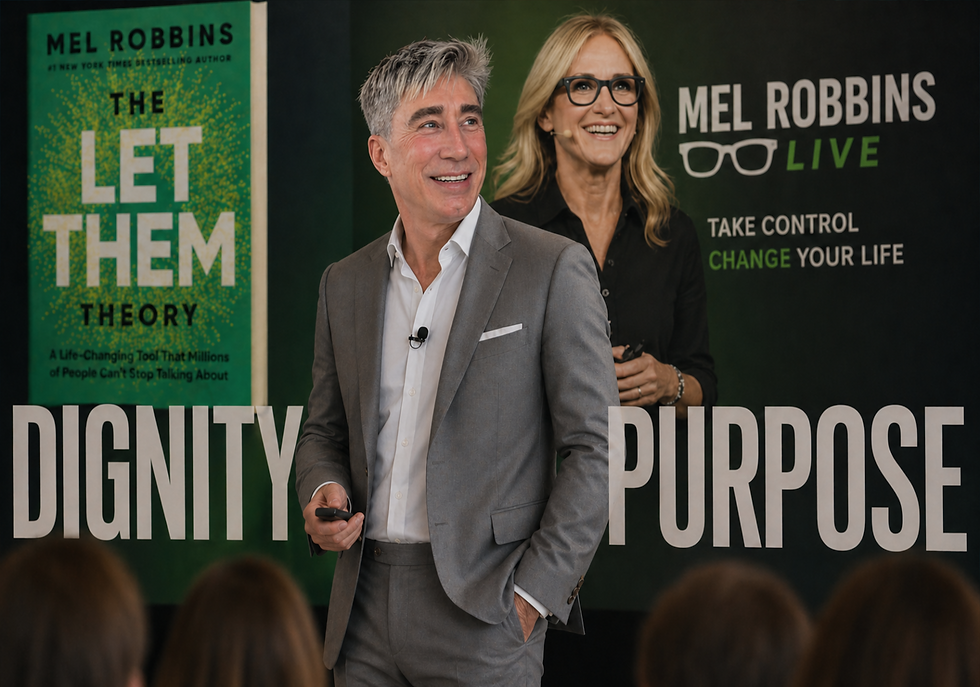 A man in a grey suit and Mel Robbins speaking on stage at a live event next to promotional banners for "The Let Them Theory."