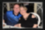 Man and woman smiling and posing together at a table.