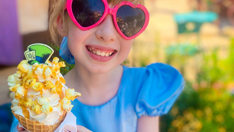 Girl in pink heart sunglasses with ice cream at Disneyland Paris during the summer