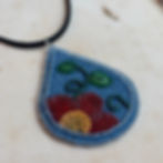 teardrop shaped denim pendant with floral beadwork