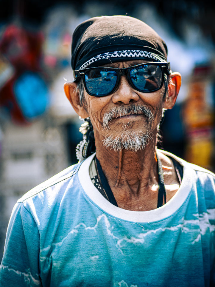 Portrait of a Thai man with a bandana and sunglasses, radiating charisma and grit.