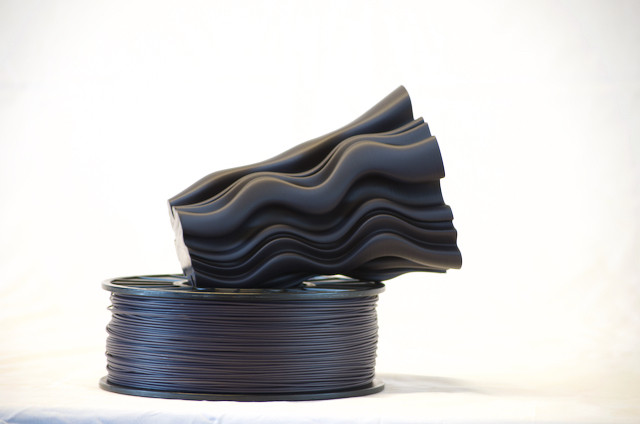 1kg spool of CLP U-HIPS filament in Nebula Black under a wavy vase printed with U-HIPS filament