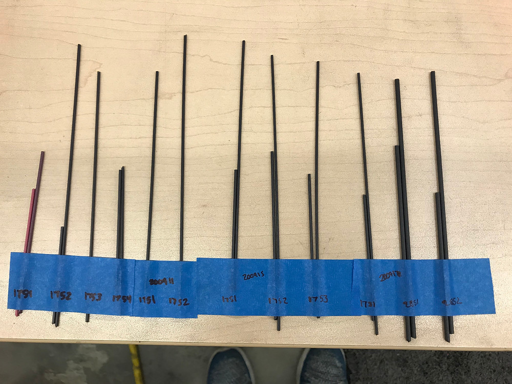 Filament sticks of different shades of black to represent the filament extruded with variations in concentration of Nebula Black powder. From the left to right the concentration increases from 1%, 2%, and 3% and repeats over 3 days