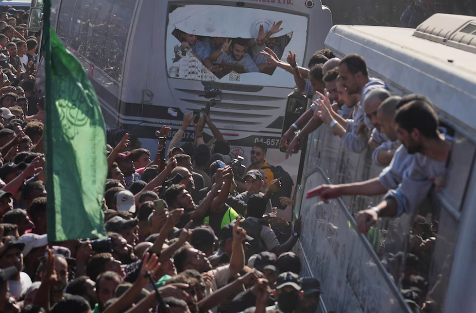 People gather to greet freed Palestinian detainees arriving on buses in the Gaza Strip after their release from Israeli jails, outside Nasser Hospital in Khan Younis, southern Gaza Strip, on October 13, 2025. Credit: Jehad Alshrafi/AP Photo