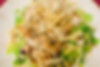 Chopped romaine lettuce tossed with shredded red cabbage, edamame, and green onion with sesame ginger oil, garnished with wonton noodles, and almonds