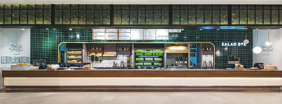 Bufet modern Salad Box, cu faianță verde și meniu afișat. Produse proaspete și sosuri expuse, iluminare caldă, atmosferă primitoare.