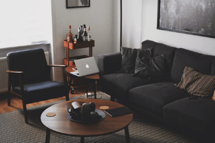 Individual counselling space with dark couch, MCM chair and table