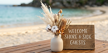 Beach picnic table with 'WELCOME SHORE & SIDE GUESTS' sign
