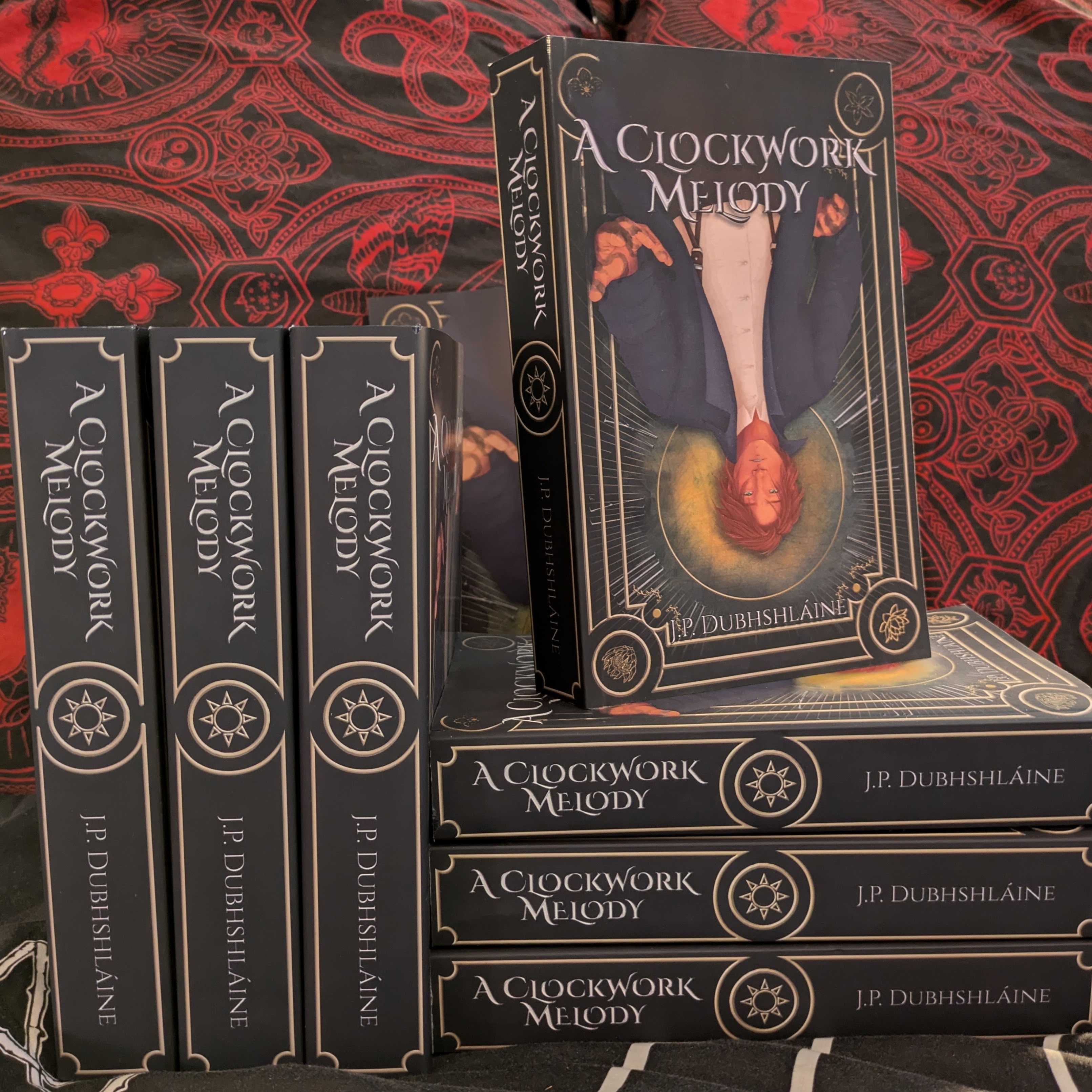 Three hardcover copies and four paperback copies of A Clockwork Melody arranged stacked together.