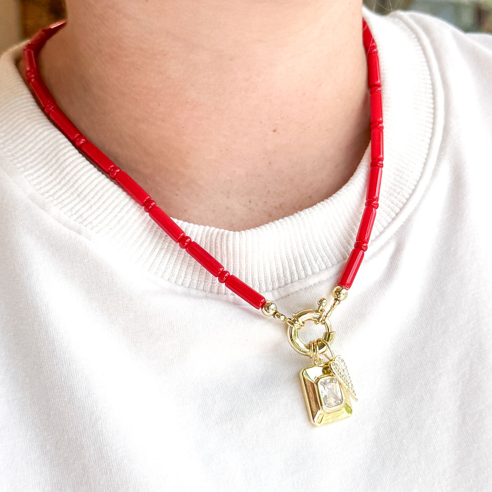 Thumbnail: Mini Regal Red Necklace styled with natural red stone beads, the Golden Gallery Charm, and Pointe Heart Charm