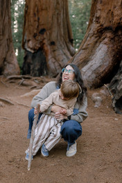 Mother laughs while holding her toddler son