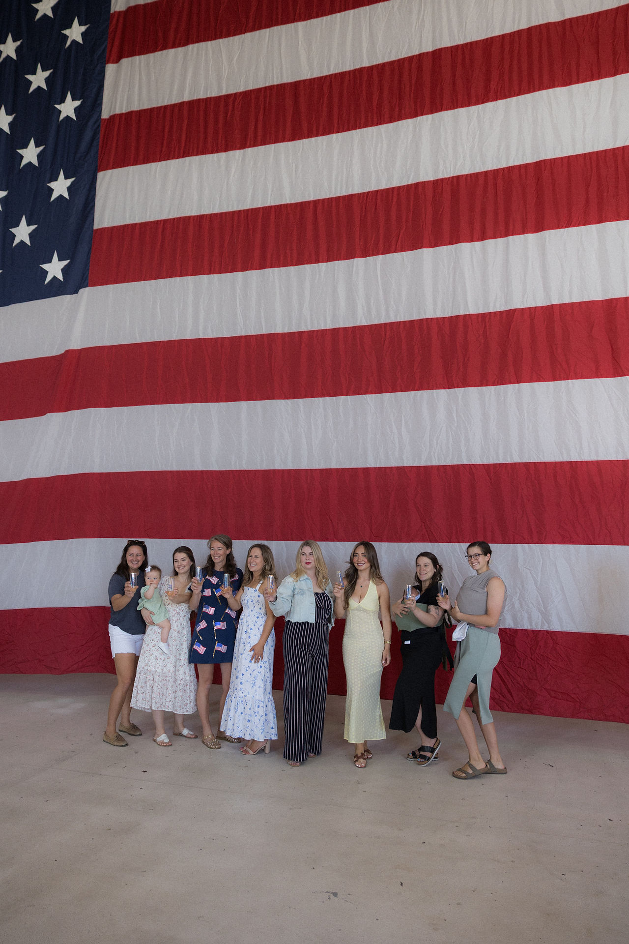 Navy spouses pose in front of giant American flag at NAS Lemoore