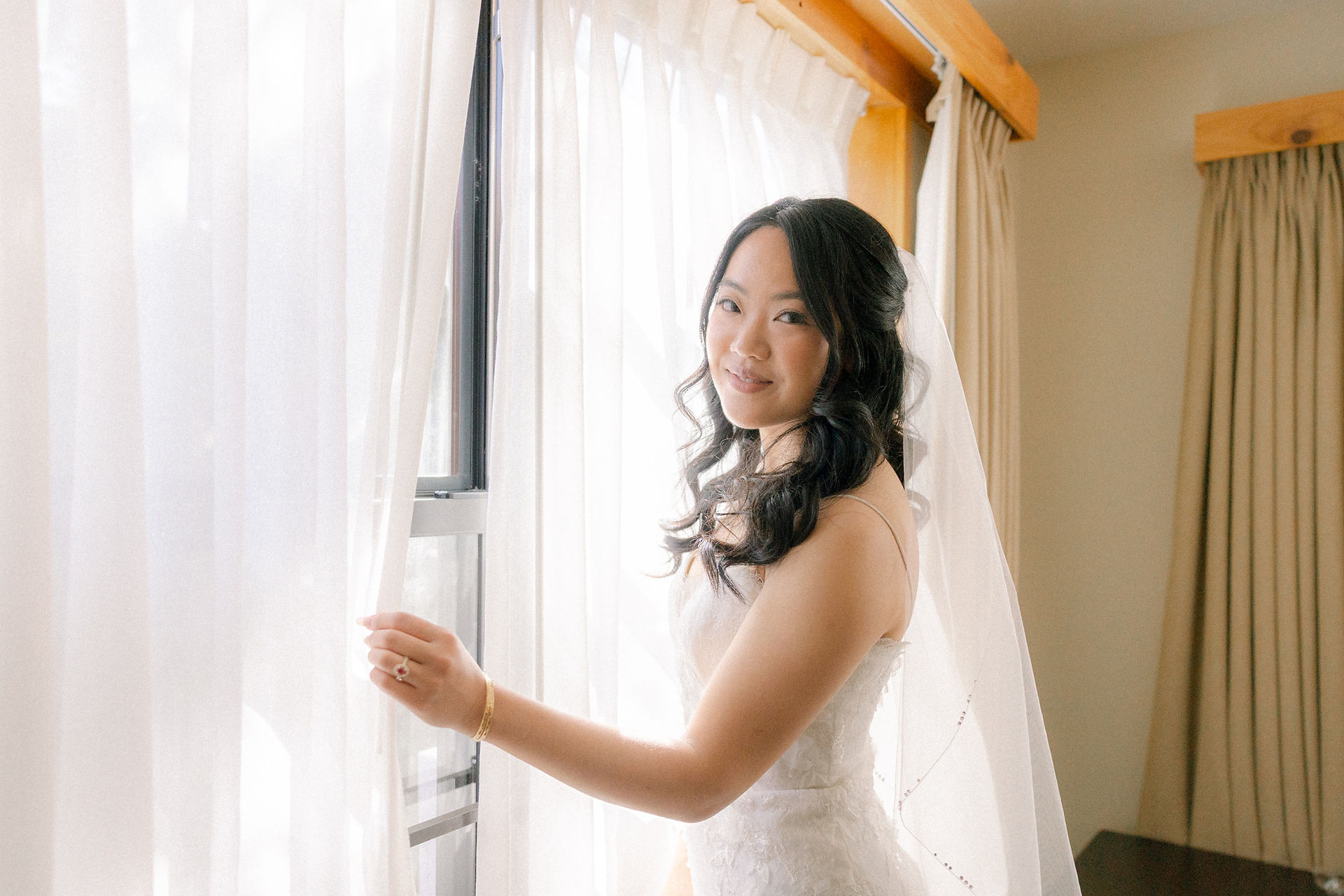 Bride poses with white curtain