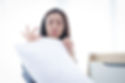 Woman examining a white pillow with a disappointed expression. She is in a well-lit room with bright curtains and striped clothing.