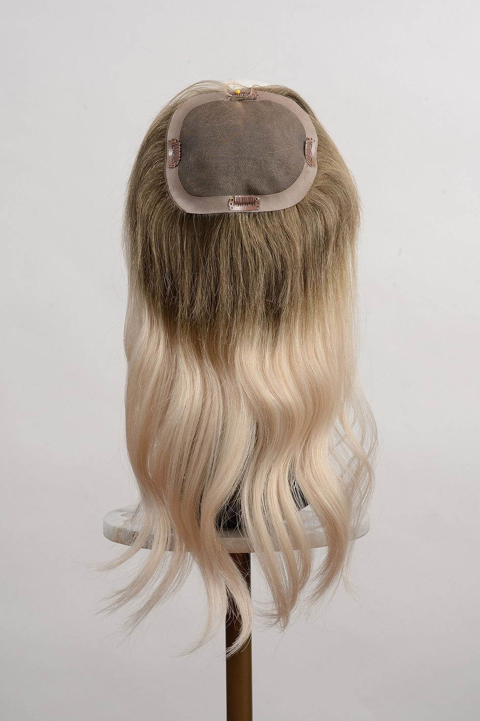 Thumbnail: Underside of a ombre blonde human hair topper extension in 16 inches lenght with a monofilament base with 4 clips